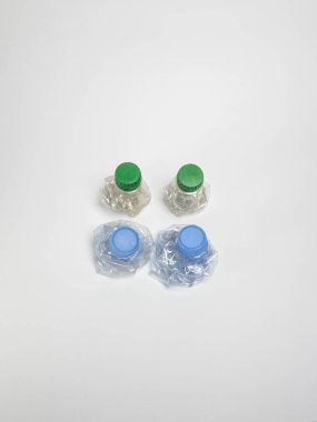 Bazıları çoktan ezilmiş ve geri dönüştürülmeye hazır plastik şişeler. Beyaz arkaplanda izole