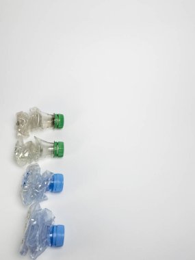 Bazıları çoktan ezilmiş ve geri dönüştürülmeye hazır plastik şişeler. Beyaz arkaplanda izole