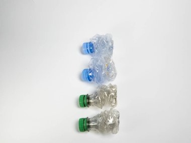Bazıları çoktan ezilmiş ve geri dönüştürülmeye hazır plastik şişeler. Beyaz arkaplanda izole