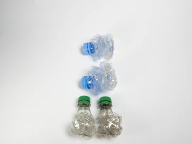 Bazıları çoktan ezilmiş ve geri dönüştürülmeye hazır plastik şişeler. Beyaz arkaplanda izole
