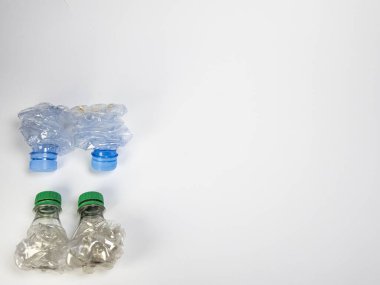 Bazıları çoktan ezilmiş ve geri dönüştürülmeye hazır plastik şişeler. Beyaz arkaplanda izole