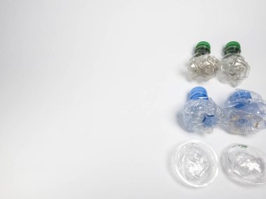 Bazıları çoktan ezilmiş ve geri dönüştürülmeye hazır plastik şişeler. Beyaz arkaplanda izole
