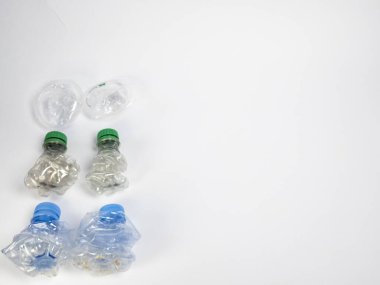Bazıları çoktan ezilmiş ve geri dönüştürülmeye hazır plastik şişeler. Beyaz arkaplanda izole