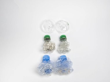Bazıları çoktan ezilmiş ve geri dönüştürülmeye hazır plastik şişeler. Beyaz arkaplanda izole