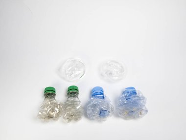 Bazıları çoktan ezilmiş ve geri dönüştürülmeye hazır plastik şişeler. Beyaz arkaplanda izole
