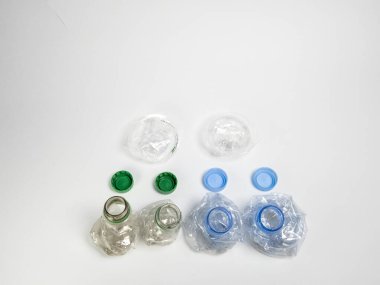 Bazıları çoktan ezilmiş ve geri dönüştürülmeye hazır plastik şişeler. Beyaz arkaplanda izole