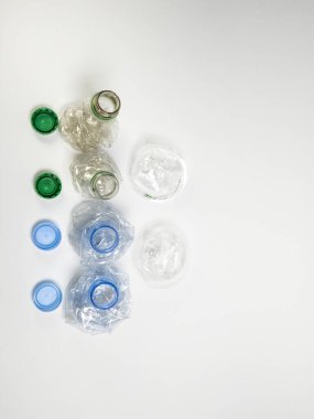 Bazıları çoktan ezilmiş ve geri dönüştürülmeye hazır plastik şişeler. Beyaz arkaplanda izole