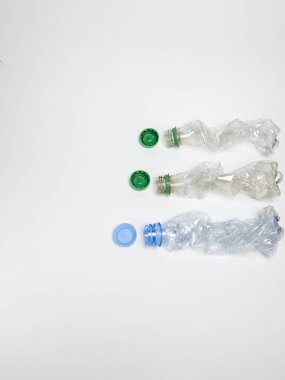 Bazıları çoktan ezilmiş ve geri dönüştürülmeye hazır plastik şişeler. Beyaz arkaplanda izole
