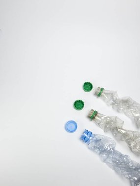 Bazıları çoktan ezilmiş ve geri dönüştürülmeye hazır plastik şişeler. Beyaz arkaplanda izole