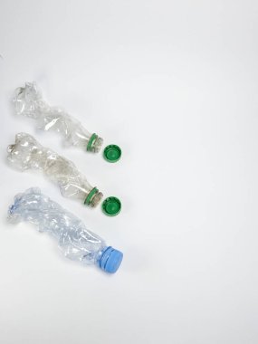 Bazıları çoktan ezilmiş ve geri dönüştürülmeye hazır plastik şişeler. Beyaz arkaplanda izole