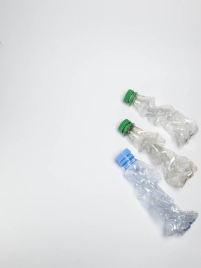 Bazıları çoktan ezilmiş ve geri dönüştürülmeye hazır plastik şişeler. Beyaz arkaplanda izole
