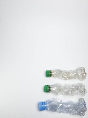 Bazıları çoktan ezilmiş ve geri dönüştürülmeye hazır plastik şişeler. Beyaz arkaplanda izole