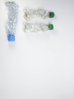 Bazıları çoktan ezilmiş ve geri dönüştürülmeye hazır plastik şişeler. Beyaz arkaplanda izole