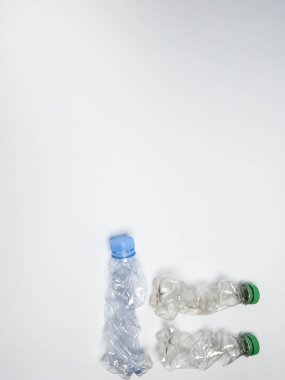 Bazıları çoktan ezilmiş ve geri dönüştürülmeye hazır plastik şişeler. Beyaz arkaplanda izole