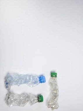Bazıları çoktan ezilmiş ve geri dönüştürülmeye hazır plastik şişeler. Beyaz arkaplanda izole