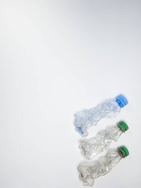 Bazıları çoktan ezilmiş ve geri dönüştürülmeye hazır plastik şişeler. Beyaz arkaplanda izole