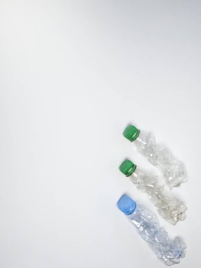 Bazıları çoktan ezilmiş ve geri dönüştürülmeye hazır plastik şişeler. Beyaz arkaplanda izole