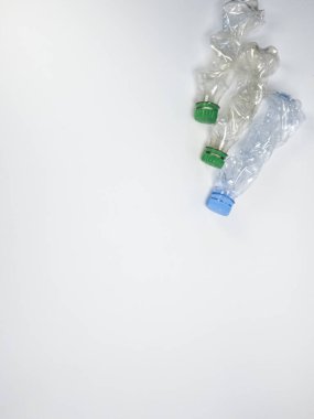 Bazıları çoktan ezilmiş ve geri dönüştürülmeye hazır plastik şişeler. Beyaz arkaplanda izole