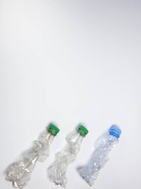 Bazıları çoktan ezilmiş ve geri dönüştürülmeye hazır plastik şişeler. Beyaz arkaplanda izole