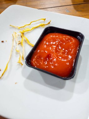 Yemekten sonra arta kalan kızarmış yemek ve ketçapla beyaz bir tabakta