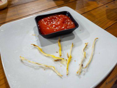 Yemekten sonra arta kalan kızarmış yemek ve ketçapla beyaz bir tabakta