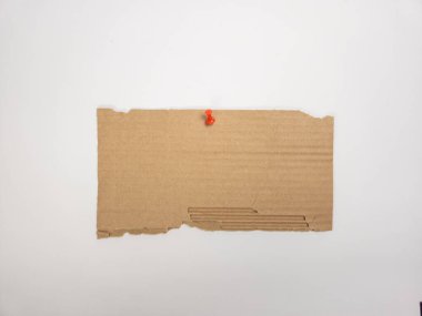 Kırmızı raptiyeli beyaz bir arka plana tutturulmuş dikdörtgen şeklinde yırtık bir karton parçası. Kartonun doğal, dokulu bir görünüşü var. Görüntü iyi aydınlatılmış ve izole, çeşitli tasarım ve kavramsal uygulamalar için uygun.