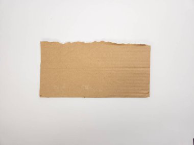 Dikdörtgen şeklinde yırtık bir karton parçası düz beyaz bir zemine yaslanmış ve minimalist bir kompozisyon oluşturmuş. Kartonun pürüzsüz, dokulu yüzeyi pürüzsüz arkaplanla çelişiyor. Dokunma gerektiren çeşitli tasarım projeleri için mükemmel