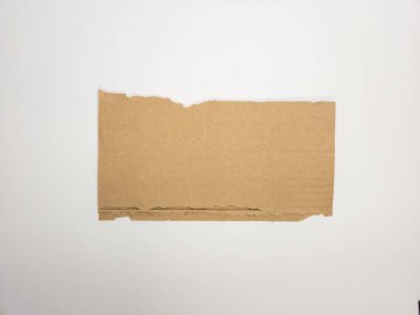 Temiz beyaz bir arkaplanda izole edilmiş kahverengi bir karton parçasının yakın çekim çekimi. Kartonun pürüzlü, pürüzlü bir kenarı var. Yırtıldığını ya da yırtıldığını gösteriyor. Resim metin ya da grafik kaplamaları için yeterli kopyalama alanı sağlar, maki