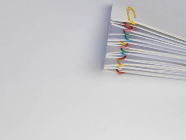 Renkli ataçlarla tutturulmuş beyaz kağıt yığınının yakın plan fotoğrafı. Kağıtlar düzgünce düzenlenmiş ve ataçlar çeşitli renklerde. Görüntü temiz ve minimalist bir estetiğe sahip. Sığ bir alan foku derinliği var.