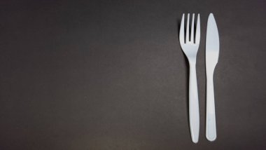 Basit bir tepeden çekimde, koyu gri bir yüzeye dikey olarak yerleştirilmiş beyaz plastik bir çatal ve bıçak bulunur. Çatal bıçaklar sağ tarafa yerleştirilmiş, sol tarafa da geniş bir kopya alanı bırakmışlar. Sahne temiz ve minimalistik. Görüntü uygun. 