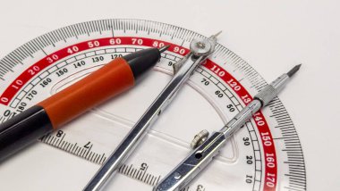 Beyaz bir yüzeye yerleştirilmiş açıölçer, pusula ve kalem de dahil olmak üzere taslak araçlarının yakın çekim görüntüsü. Enstrümanların detaylarına odaklanarak, tasarımlarını ve hassas ölçümler ve geometrik yapı için nasıl kullanıldıklarını gösterir.