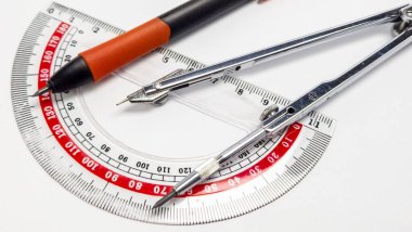 Detaylı bir yakın çekim fotoğraf, şeffaf bir açıölçer, gümüş bir pusula ve bir kalem de dahil olmak üzere temel geometri araçlarını sergiler. Bileşimi keskindir, beyaz ve temiz bir arkaplana karşı araçların hassasiyetini ve tasarımını vurgular. Kusursuz