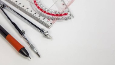 Bir açıölçer, cetvel ve pusula da dahil olmak üzere temiz beyaz bir arkaplan üzerinde yakın plan çekim görüntü taslak araçları. Görüntü, araçların geometri, mühendislik veya tasarım alanlarındaki kullanımlarını vurgulayarak hassasiyet ve detaylarını vurgular. Bileşik.