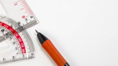 Bu yakın plan resim beyaz bir yüzeye yerleştirilmiş bir kalem, bir açıölçer ve bir cetvel içerir. Kompozisyon basit ve araçları vurguluyor, geometri, çizim veya eğitime odaklanmayı öneriyor. Görüntü iyi aydınlatılmış ve net, uygun f