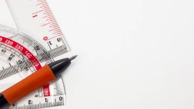 Beyaz arka planda cetvel, açıölçer ve kalem gibi kırtasiye malzemelerinin yakın plan çekimi. Görüntü temiz, parlak ve eğitim, tasarım ya da ofis işleri temaları için idealdir. Kompozisyon, ortak araçları vurgular