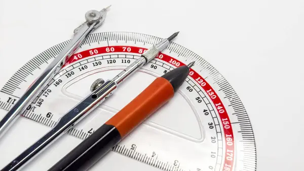 Yakın plan çekimde, temiz beyaz arka planda temel taslak araçları sergilenir. Görüntü bir açıölçer, bir pusula ve bir teknik kalem içerir. Araçlar görsel olarak çekici bir kompozisyonda düzenlenerek, tasarımları ve işlevsellikleri vurgulanıyor. Th