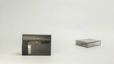 MiniDV kameralı bir stüdyo görüntüsü ve temiz beyaz bir arkaplana karşı koruyucu davası. Kamera siyah ve çeşitli düğmeleri ve yuvaları var. Çanta ise şeffaf. Işıklandırma yumuşak ve düz, ayrıntıları vurguluyor