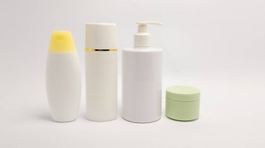 Cilt bakımı ve kozmetik ürün konteynırları sergilenen bir stüdyo resmi. Resim beyaz bir arkaplan içeriyor, temiz çizgiler ve konteynırların basit tasarımı vurgulanıyor. Şişeler ve kavanozlar sıraya dizildi, Cohe 'u temsil ediyor.