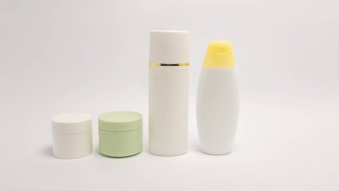 Kavanozlar ve şişeler de dahil olmak üzere bir kozmetik ürünü seçimi, düz beyaz bir arkaplana göre düzenlenir. Ürünler tarafsız renklerde, temiz ve minimalist bir estetik sunuyorlar. Kompozisyon basit ve dağınık. Güzellik için ideal.