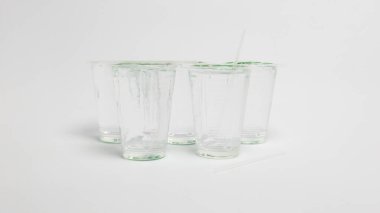 Stüdyoda, bazıları kamışlı temiz plastik bardaklardan oluşan bir koleksiyon, el değmemiş beyaz bir arkaplana karşı düzenlenmiş. Bardaklar boş ve temiz görünüyor. Bu da basitlik ve minimalizme odaklandığını gösteriyor. Işıklandırma yumuşak ve eşit, C 'yi arttırıyor.