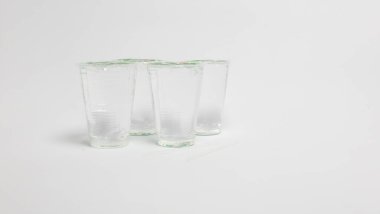Bir stüdyo çekiminde, her birinin kapağı beyaz bir yüzey üzerinde birbirine yakın sıralanmış dört temiz plastik bardak yer alır. Bardakların yanında iki pipet vardı. Görüntü, nesnelerin basitliğini vurgulayan, yumuşak ışıklandırmalı ve minimalist bir estetiğe sahiptir.