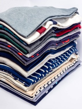 Yakın plan çekimlerde düzgünce düzenlenmiş katlanmış giysiler sergilenir. Kıyafetler mavi, beyaz, yeşiller, kırmızılar ve griler gibi çeşitli renklerde, çizgiler ve katı renkler gibi çeşitli desenlere sahiptir. Görüntü iyi aydınlatılmış ve odaklanmış. 