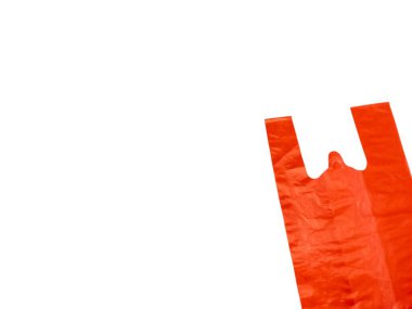 Temiz beyaz arka planda izole edilmiş parlak turuncu plastik bir alışveriş çantasının yakın çekimi. Poşet buruşmuş ve katlanmış. Görüntü iyi ışıklandırılmış ve minimalist bir estetiğe sahip. Bu resim, adv de dahil olmak üzere çeşitli bağlamlarda kullanmak için uygundur