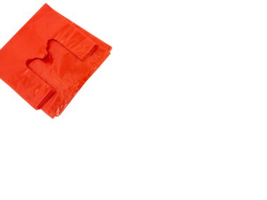 Temiz beyaz arka planda katlanmış parlak kırmızı plastik bir alışveriş çantasının yakın çekimi. Poşet biraz buruşmuş, bu da kullanıldığını ya da kullanıldığını gösteriyor. Görüntü iyi aydınlatılmış, plastiğin dokusunu ve rengini vurguluyor. Tam oldu. 