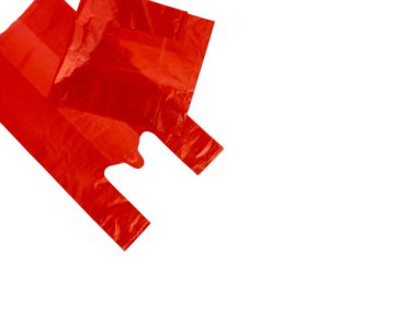 Temiz, beyaz bir arka planda izole edilmiş parlak kırmızı plastik alışveriş torbalarının yakın çekimi. Poşetler biraz buruşmuş, bu da kullanım anlamına geliyor ve çerçeve boyunca köşegen olarak açılandırılmış. Görüntü ışıl ışıl parlıyor, canlı renkleri gösteriyor ve...