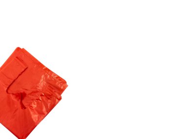 Temiz beyaz arka planda çapraz yerleştirilmiş parlak kırmızı plastik alışveriş çantalarının yakın plan çekimi. Poşetler biraz buruşmuş, kullanıldığını ya da kullanılmaya hazır olduğunu gösteriyor. Görüntü dokuyu ve canlı rengi vurgular.