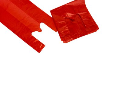 Beyaz arka planda izole edilmiş birkaç kırmızı plastik alışveriş çantasının yakın çekimi. Çantalar yeni ve kullanılmamış, temiz ve parlak bir görünüşü var. Bir çanta açılır ve diğerleri istiflenirken düz bir şekilde yatar. Bu resim resim resim için mükemmel.