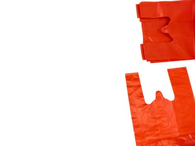 Birkaç kırmızı plastik poşet beyaz arka planda izole edilir. Çantalar bir kompozisyonda dizilir, bazıları istiflenir ve diğerleri yayılır. Parlak kırmızı renk, çantaların şeklini ve materyalini vurgulayan beyaz arkaplanla çelişiyor.