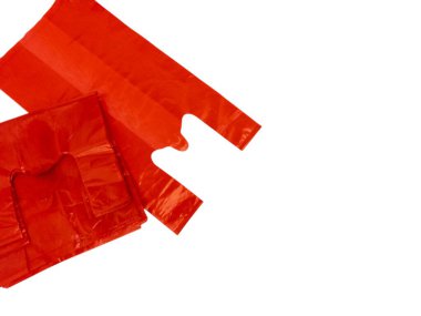 Beyaz arka planda izole edilmiş kırmızı plastik poşetlerin stüdyo çekimi. Çantalar üst üste binen bir kompozisyonda dizilmiş, şekillerini ve dokularını gösteriyor. Resim metin veya diğer tasarım ögeleri için yeterli kopya alanı sağlar. Titreşim.