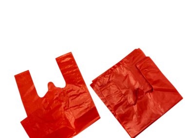 Beyaz arka planda iki kırmızı plastik poşet. Torbalardan biri açık ve düz, tutacakları gösteriyor, diğeri ise katlı. Poşetler parlak plastikten yapılmış ve yeni gibi görünüyor. Perakende, market ya da çevre dostu kavramlar için ideal. Çok. 